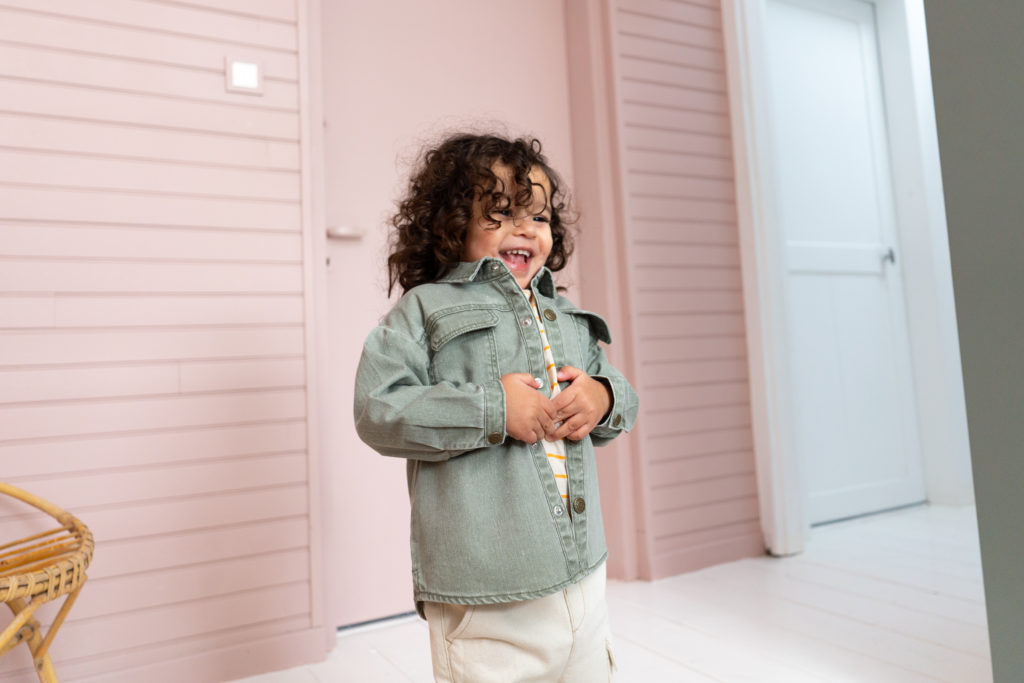 enfant qui rit avec une veste en jean