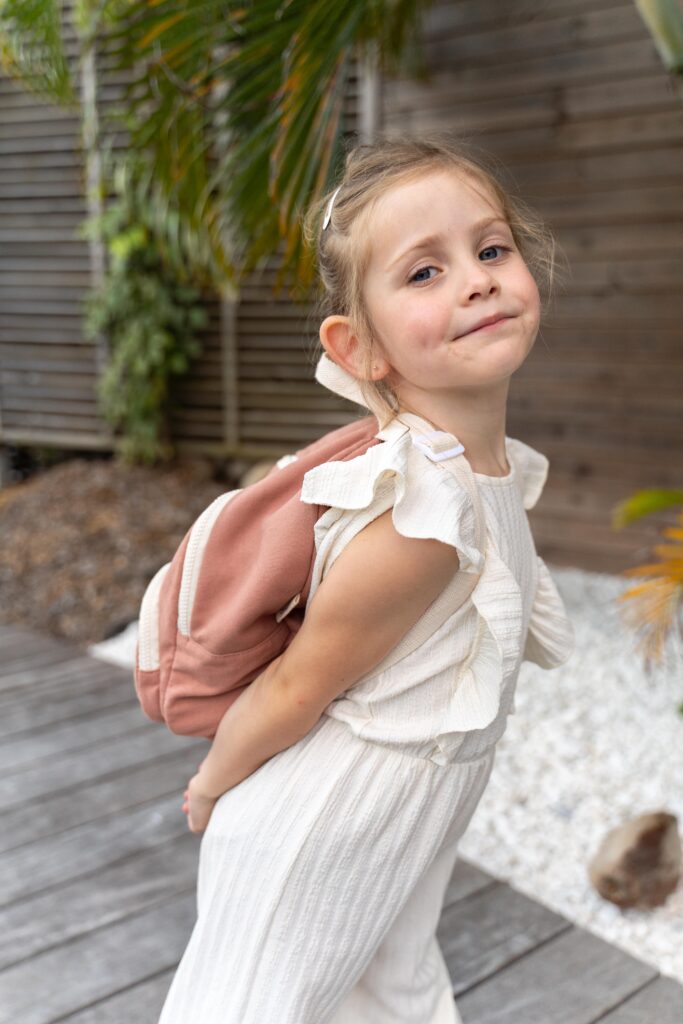 Fille avec une combinaison blanche et un sac à dos romea