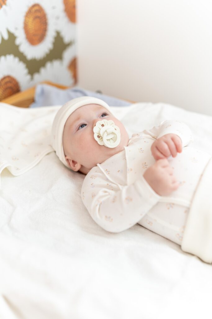 bébé allongé avec une tétine dans la bouche