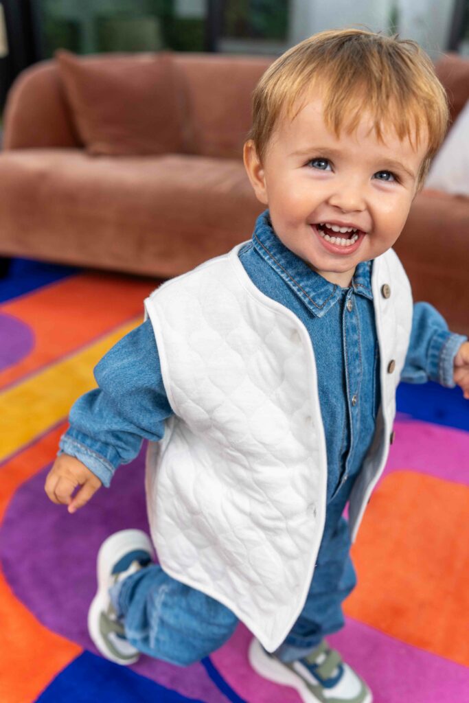 garçon avec une veste sans manche et une combinaison en jean