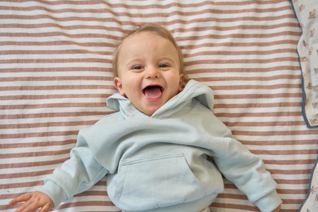 petit garçon qui rit sur un lit